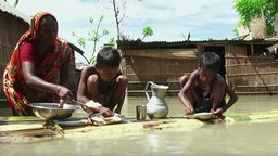 A mother struggles to feed her children in the face of flooding (Image: IIED Independent Expert Group)