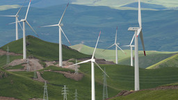 Wind power turbines and electricity pylons alongside one another in China