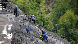 Miners on a steep hillside mine tungsten