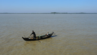 A fisher in a boat in the Ayeyarwady Delta, Myanmar