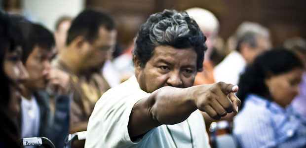 A man points his finger at someone in a meeting room at a debate at a meeting on the sustainable development of the Amazon at Rio+20.