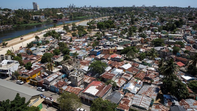 Aerial view of housing with metal roofs, palm trees and a river