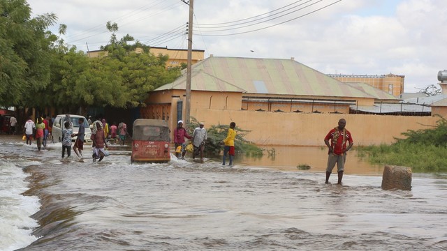 People walking on a flooded street.